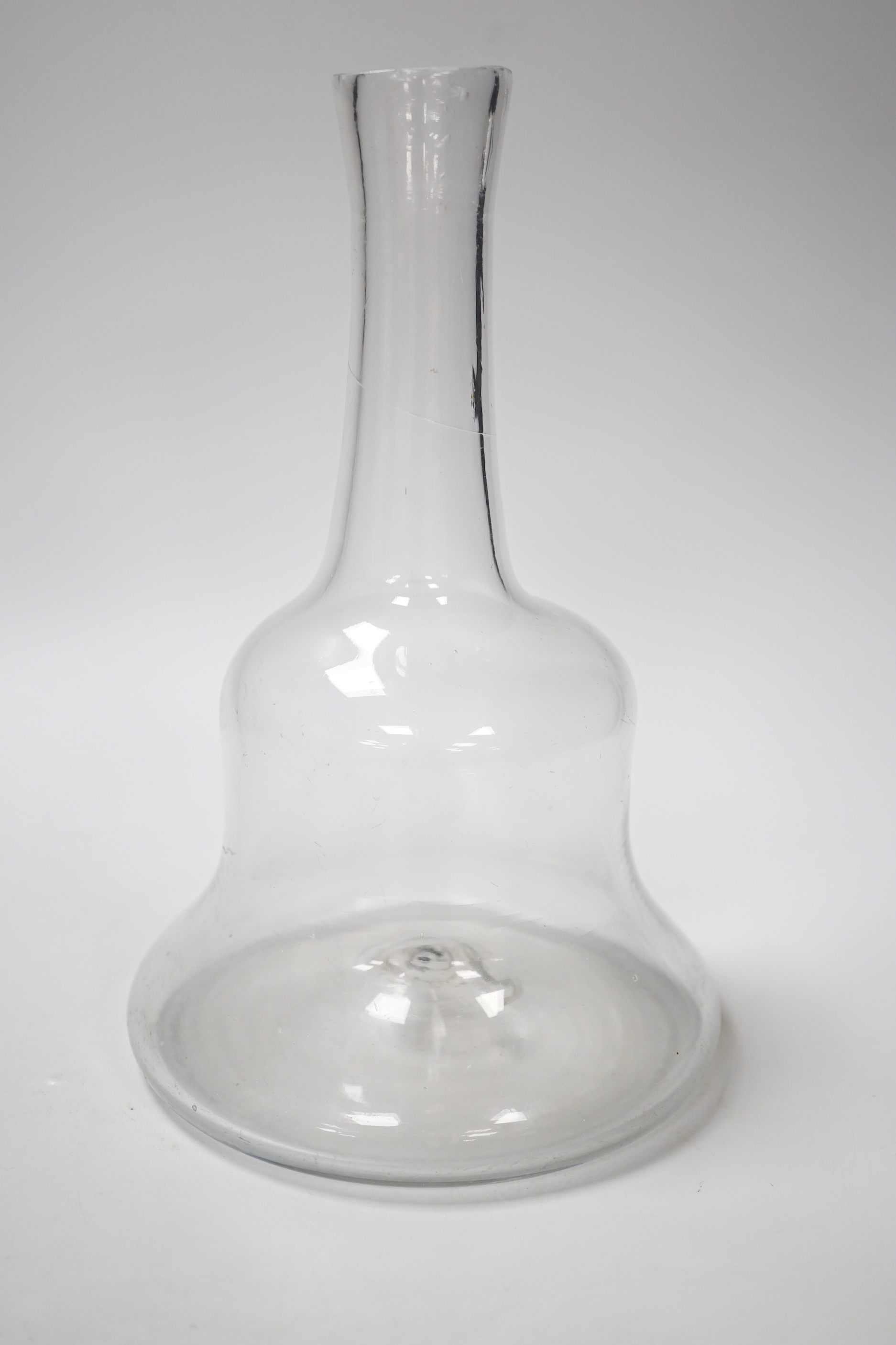 An early 18th century English lead crystal serving bottle, of long shaft and globe in the form of a bell, 23.5cm high